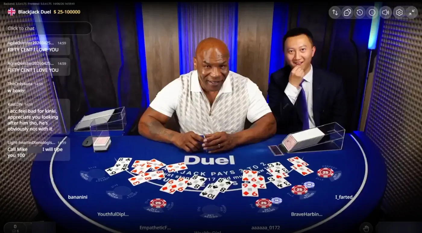 Mike Tyson in a white shirt behind the Duel Blackjack Live table, cards on the blue Duel felt, the stream chat on the left and the stream clock reading 14/06/26